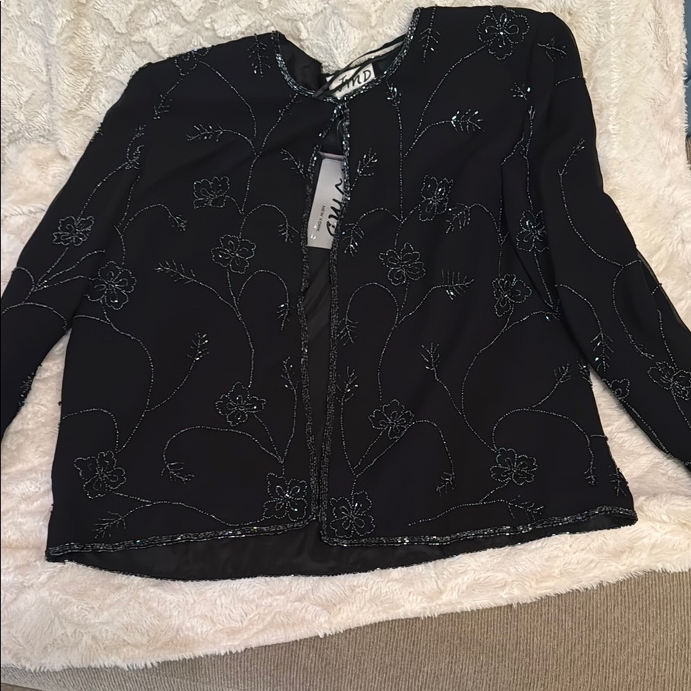 Sophisticated and dressy black coat. Floral sequin design.